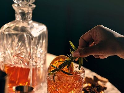 Dégustation de spiritueux au bar Maison Amour à Tours, servi dans un verre en cristal avec zestes et herbes aromatiques